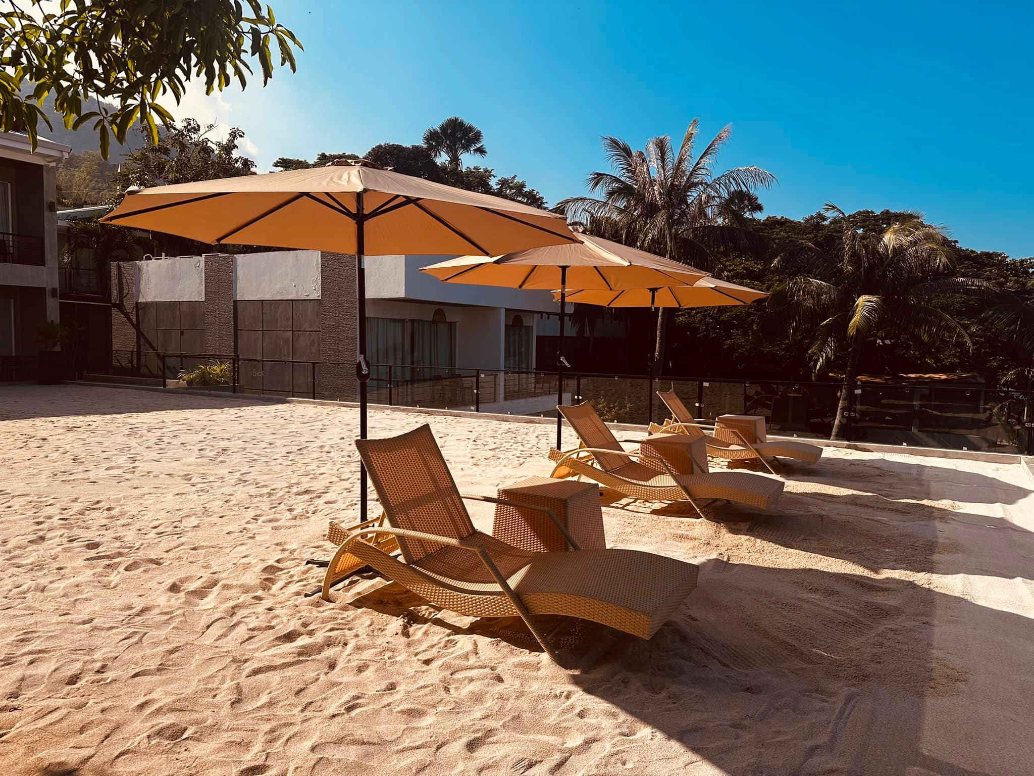 Sandy lounge area with umbrella chairs