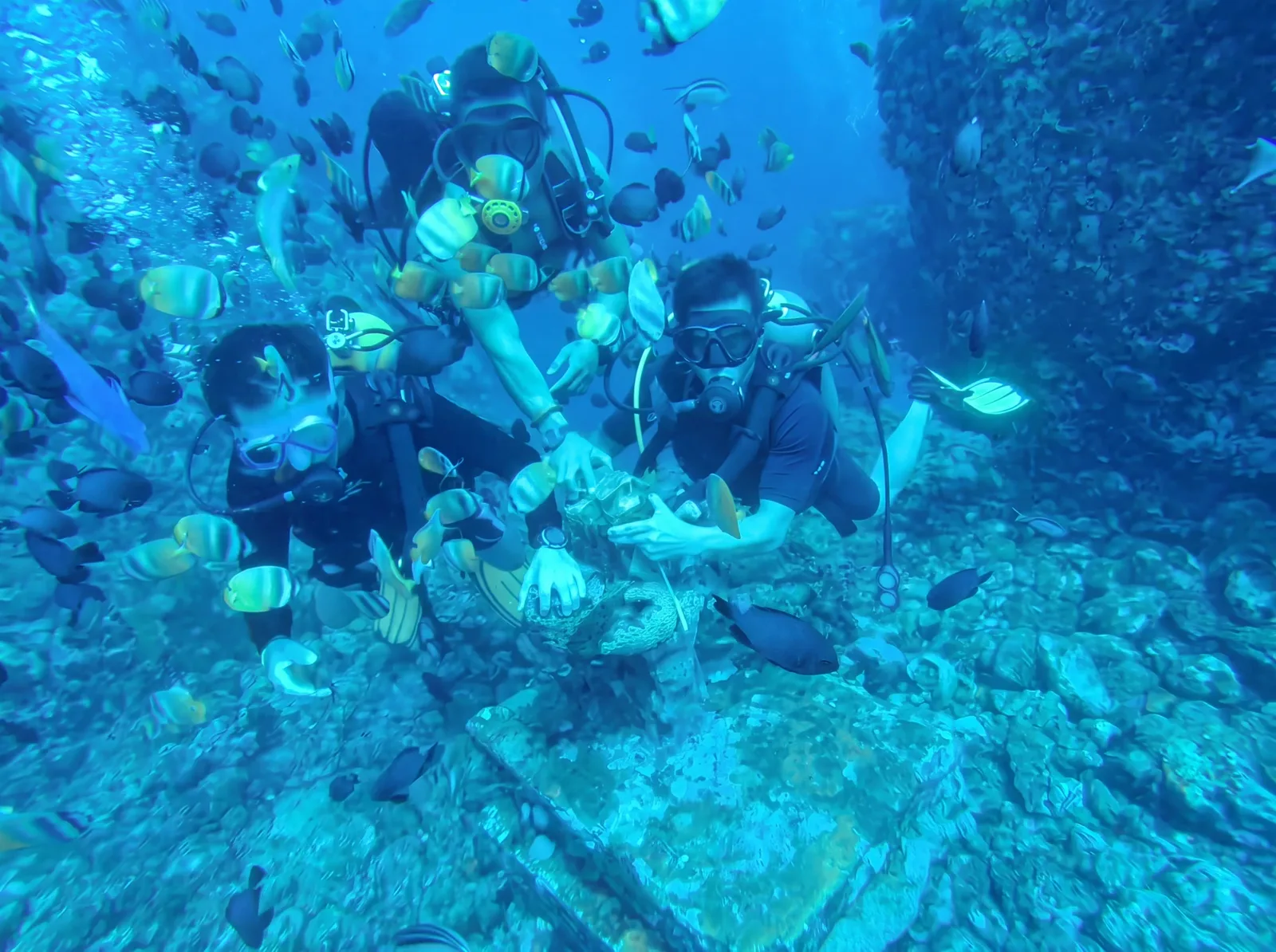 Divers on the reef among tropical fish in Anilao